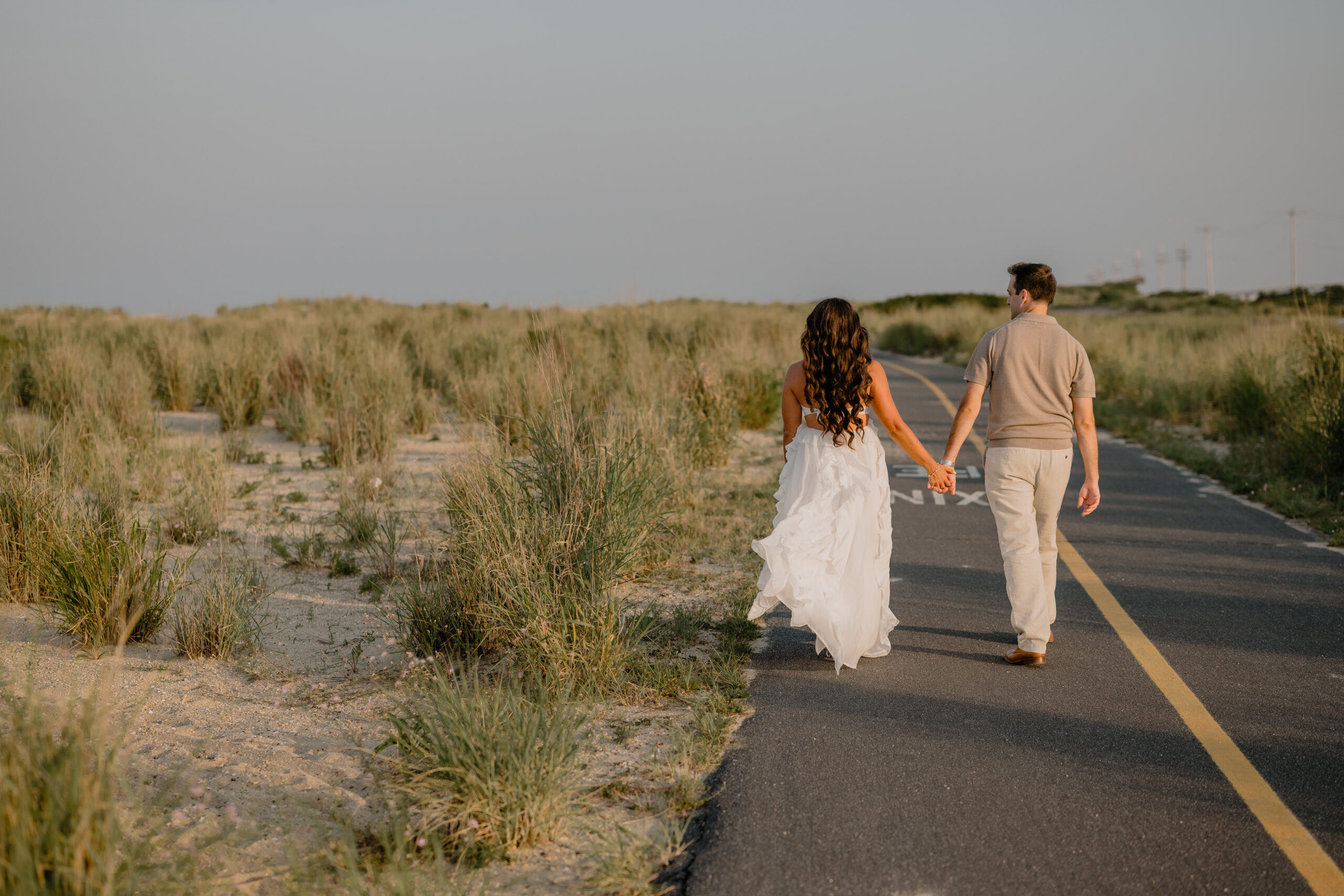 Couple walking while holding hands during their Deep Cut Gardens & Sandy Hook Beach Engagement Session