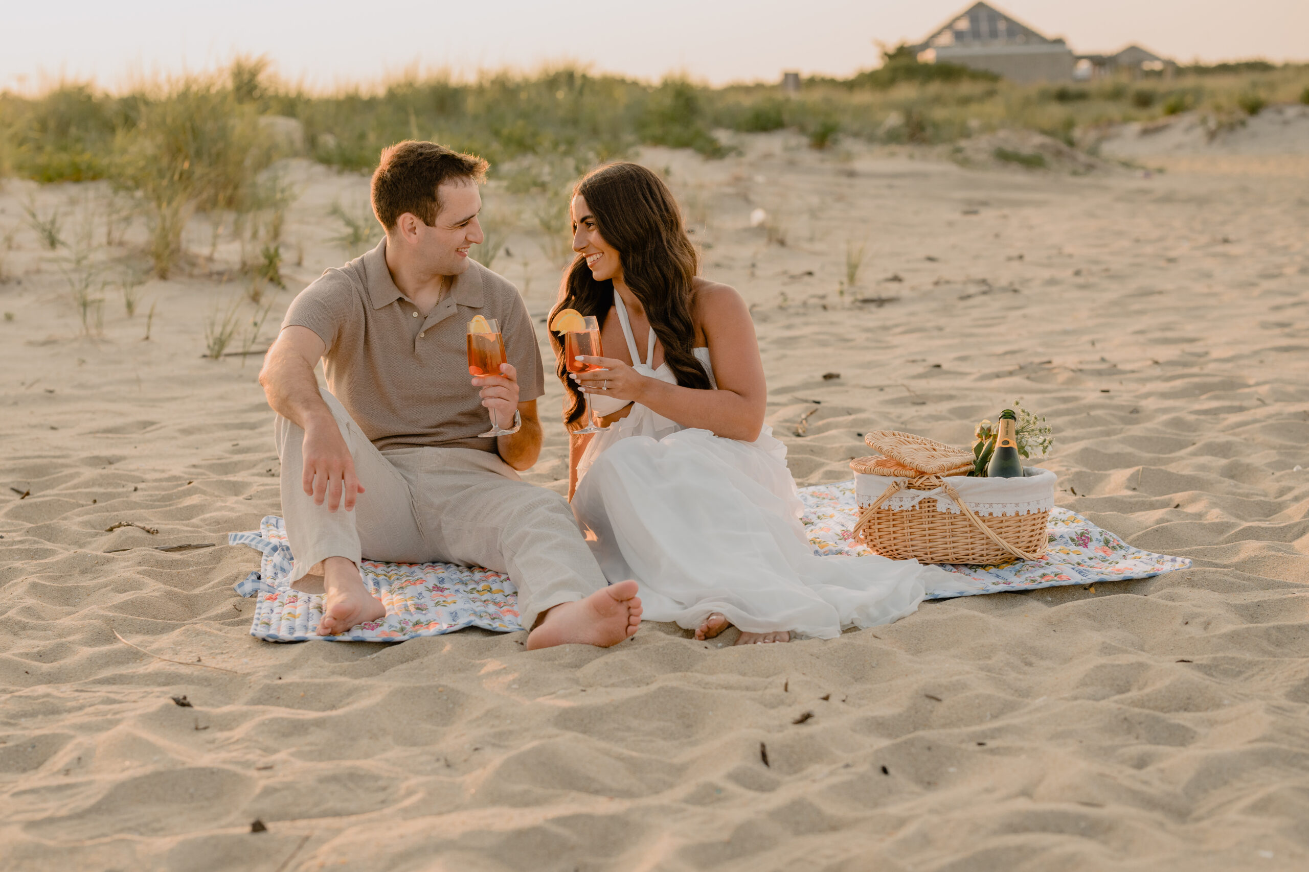 Couple having a picnic by the beach during their Deep Cut Gardens & Sandy Hook Beach Engagement Session