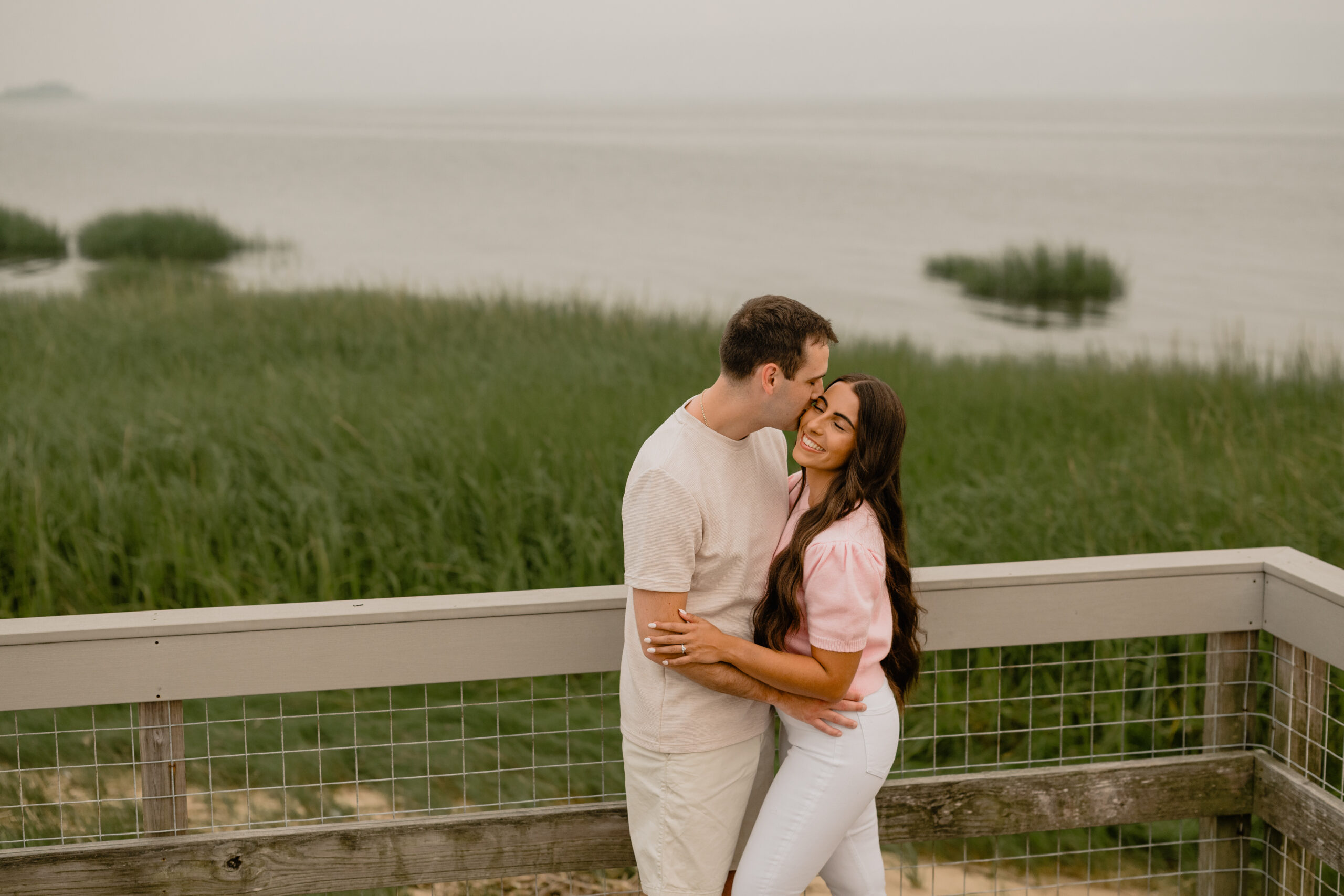 Man kissed the woman on the cheek during their Deep Cut Gardens & Sandy Hook Beach Engagement Session