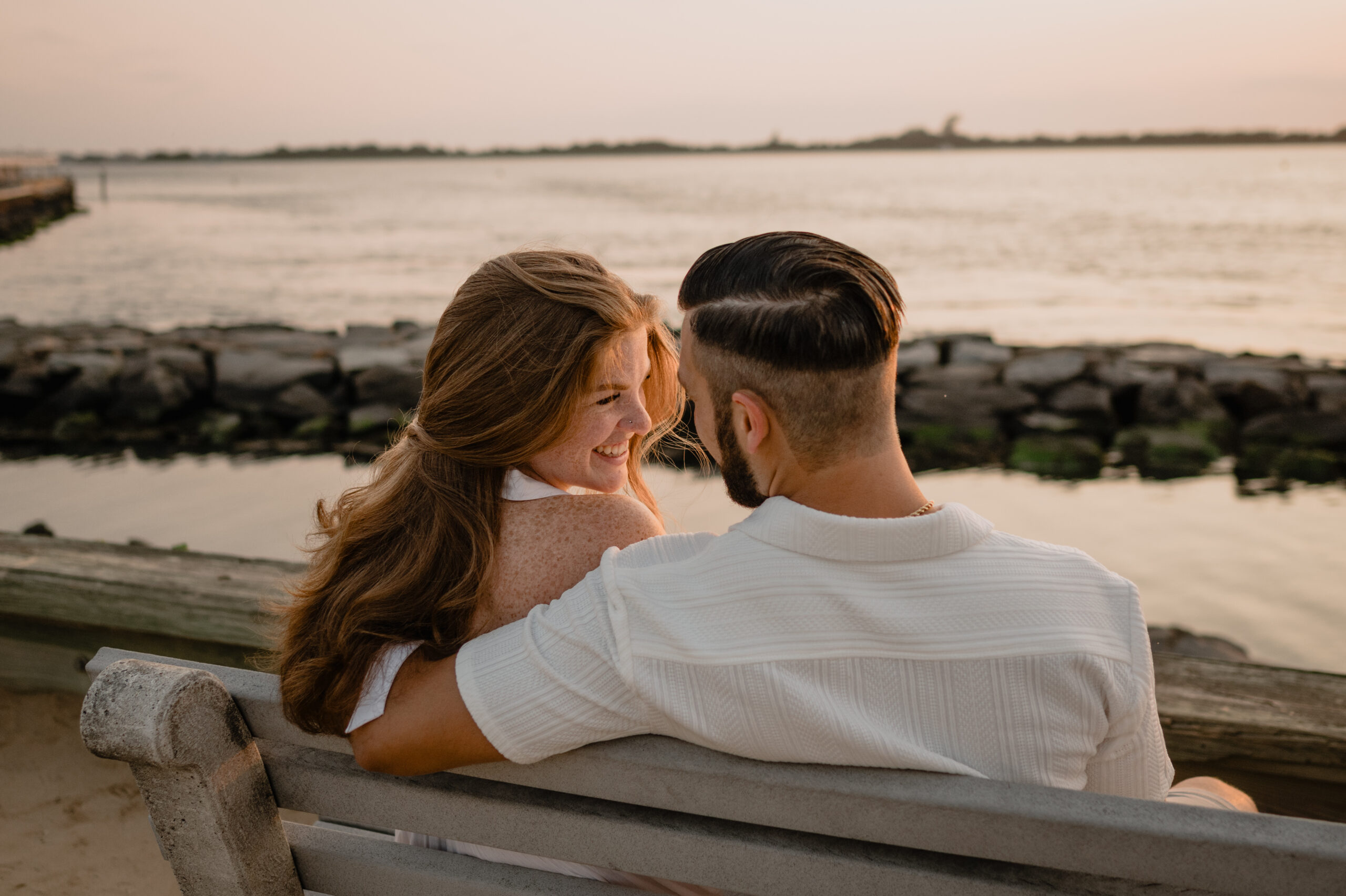 Couple sitting on a bench during their Engagement Session at Barnegat Lighthouse