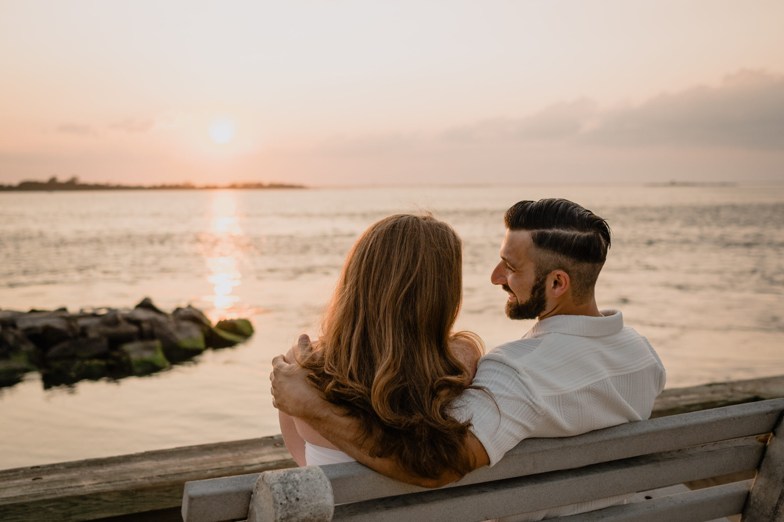 Couple sitting on a bench during their Engagement Session at Barnegat Lighthouse