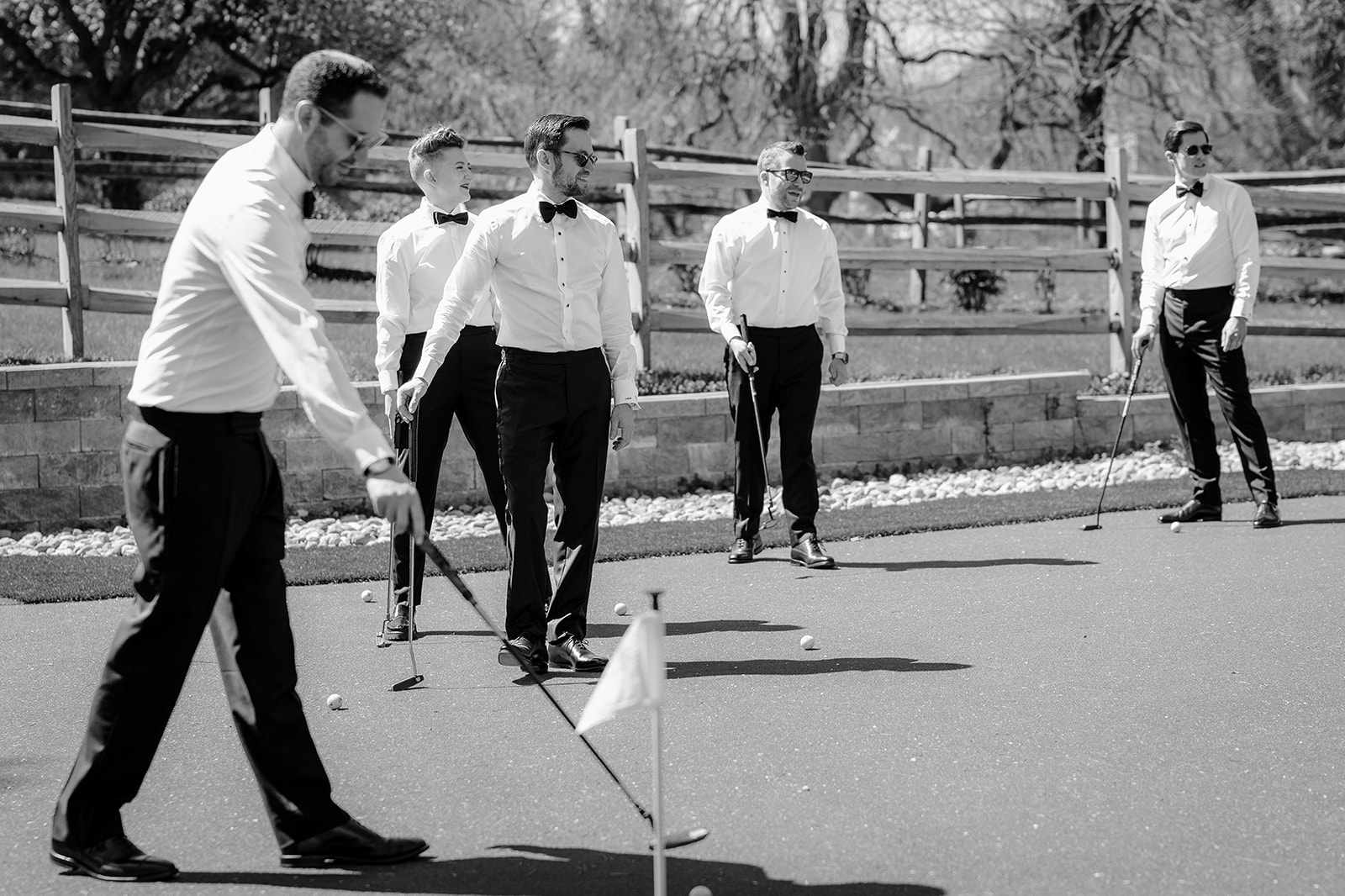 Groom playing golf with the groomsmen before their beautiful wedding at Crossed Keys Estate.