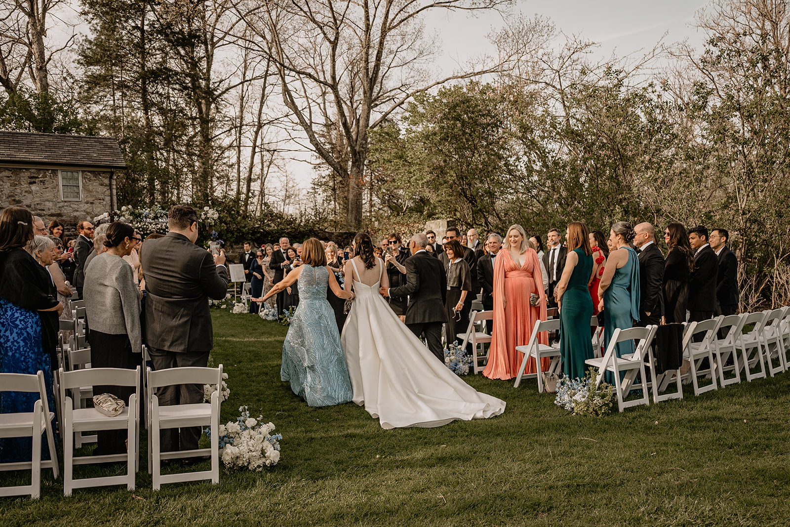 Bride walking down the aisle with her parents during their beautiful wedding at Crossed Keys Estate.